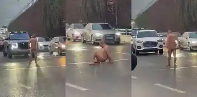 街头马路上一纹身光头男赤裸在路中间拦截过往车辆 欲有一人当关万夫莫开的气势