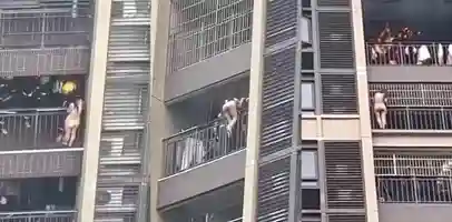 一小区高楼发生火灾 女子全裸悬挂在楼体外 向下攀爬捡回一条命